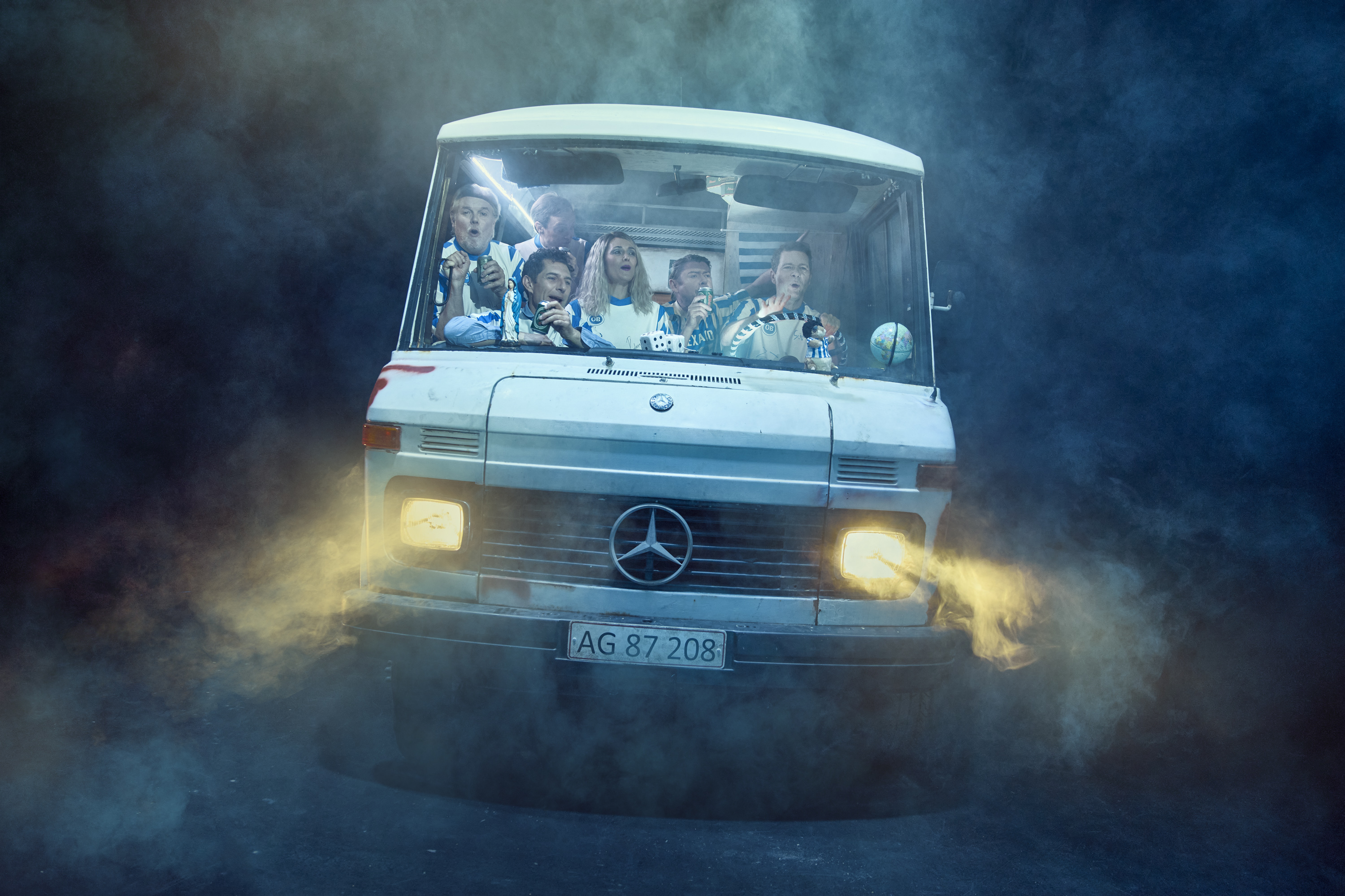 En flok mennesker sidder i en autocamper. Fra teaterforestillingen Miraklet i Madrid på Odense Teater