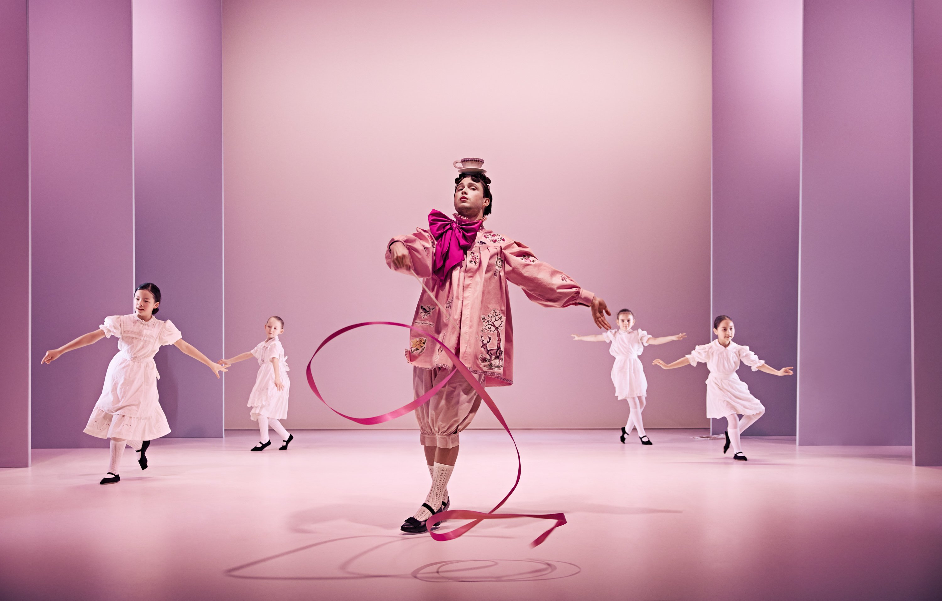 Den snobbede bror fra Klodshans med vimpel og dansende balletbørn klædt i hvidt. Fra Teaterforestilling Klodshans på Odense Teater