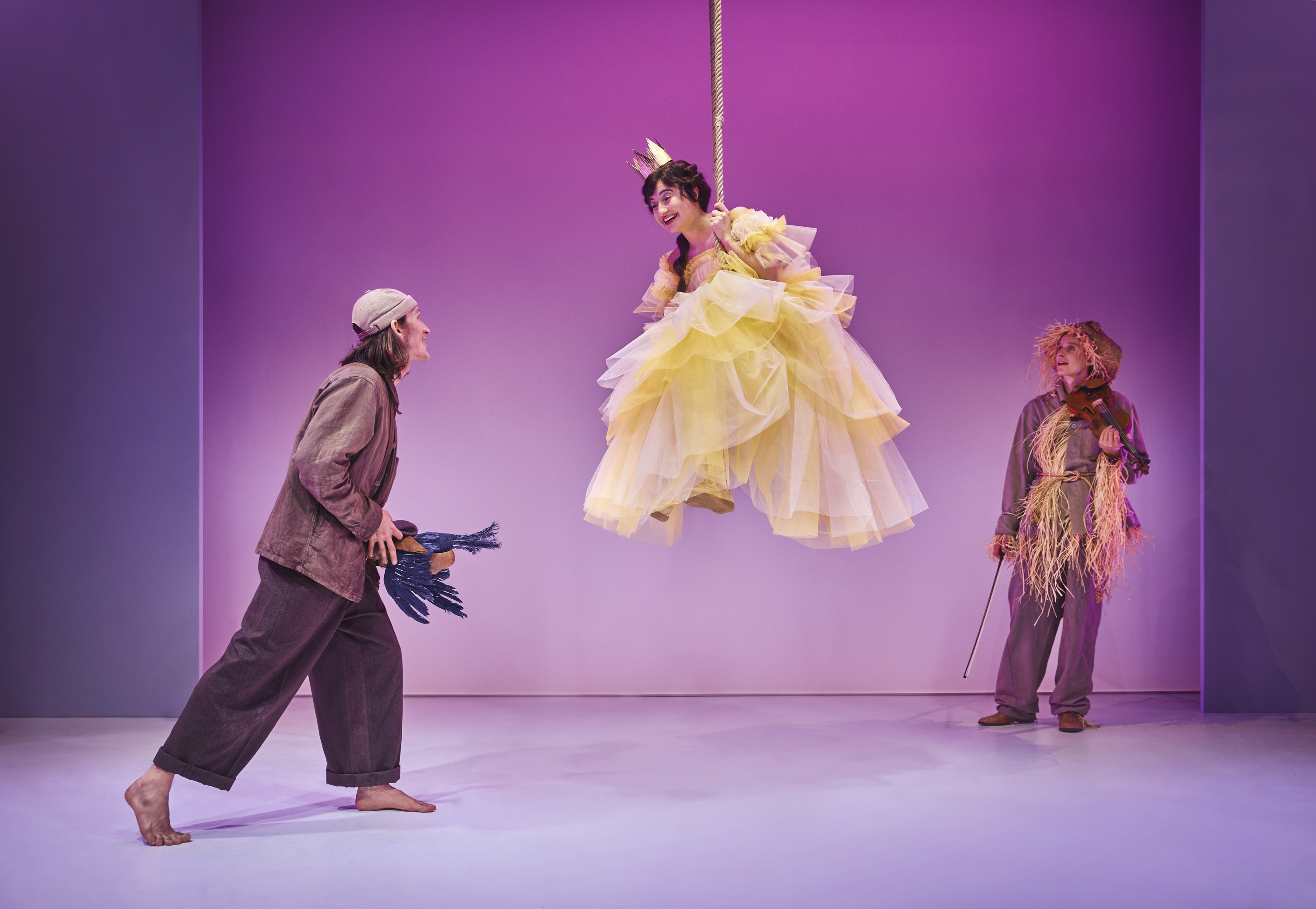 Prinsessen i gul kjole svæver i luften på gynge mens Klodshans med død krage ser på. Teaterforestilling på Odense Teater