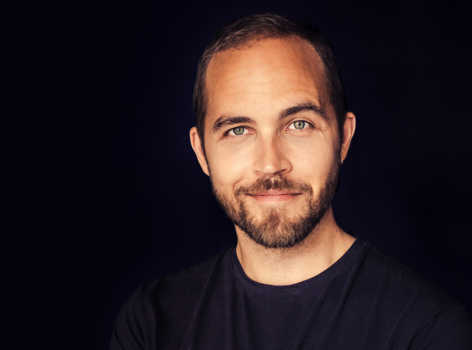 Skuespiller Alexander Clement. Portrætbillede på mørk baggrund.