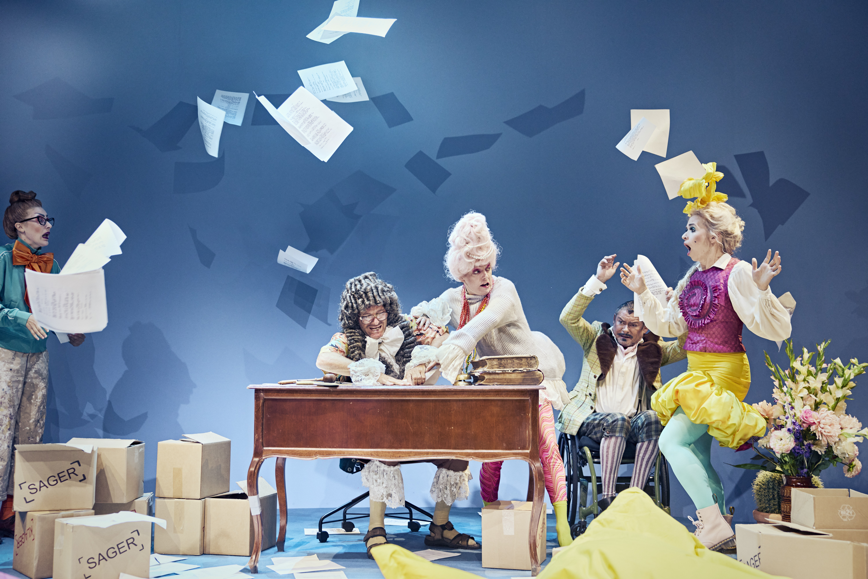 Et kaos billede med 5 personer. Papirer flyver op i luften. Fra teaterforestillingen Den politiske kandestøber på Odense Teater