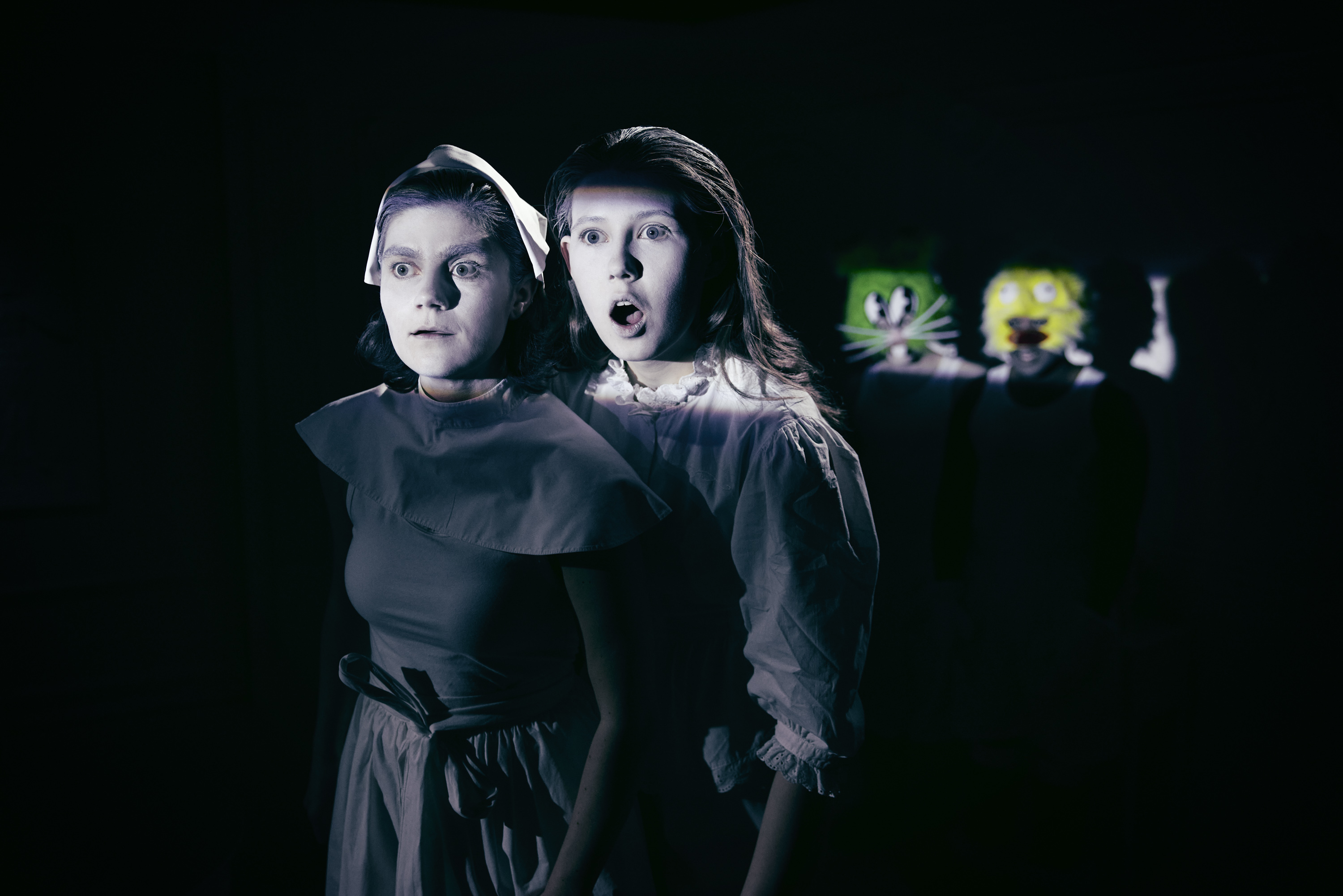 To kvinder klædt i sort i mørkt rum. Malet hvide i ansigt. Fra forestilling Resten kender du fra film på Odense Teater