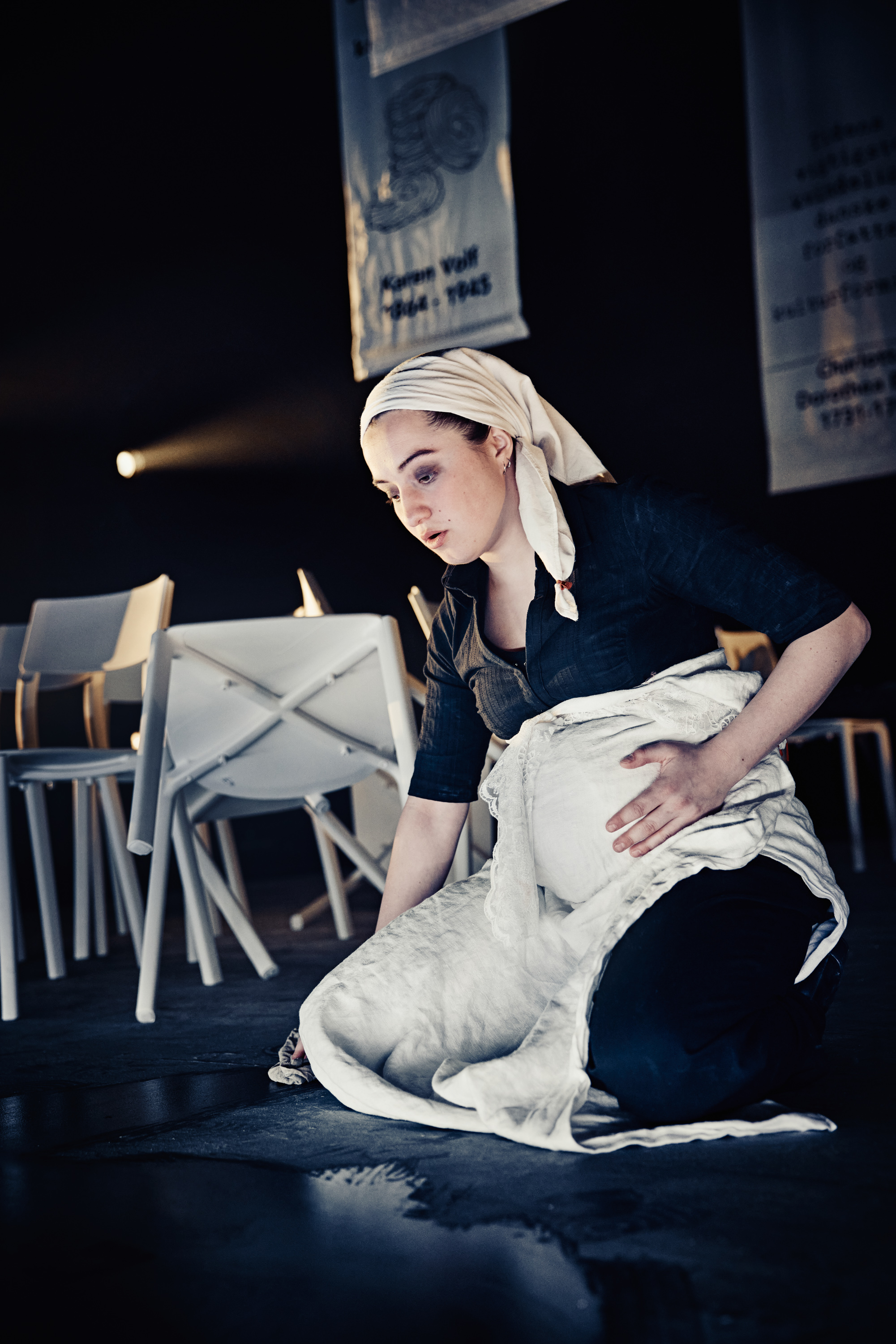 Gravid kvinde skurer gulv og tager sig til sin mave. Fra forestilling Kvinde kend din historie på Odense Teater