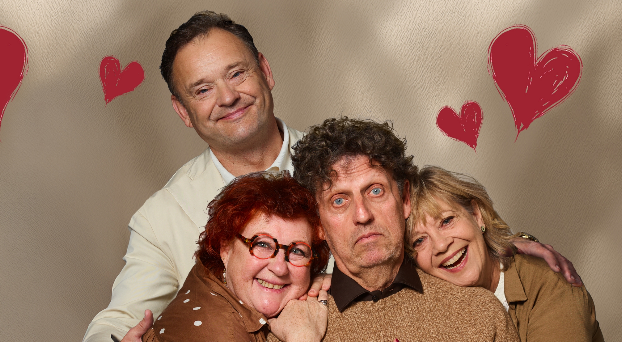 2 mænd og 2 kvinder i brunt og sandfarvet tøj ser smilende ind i kameraet. Sandfarvet baggrund med tegnede røde hjerter
