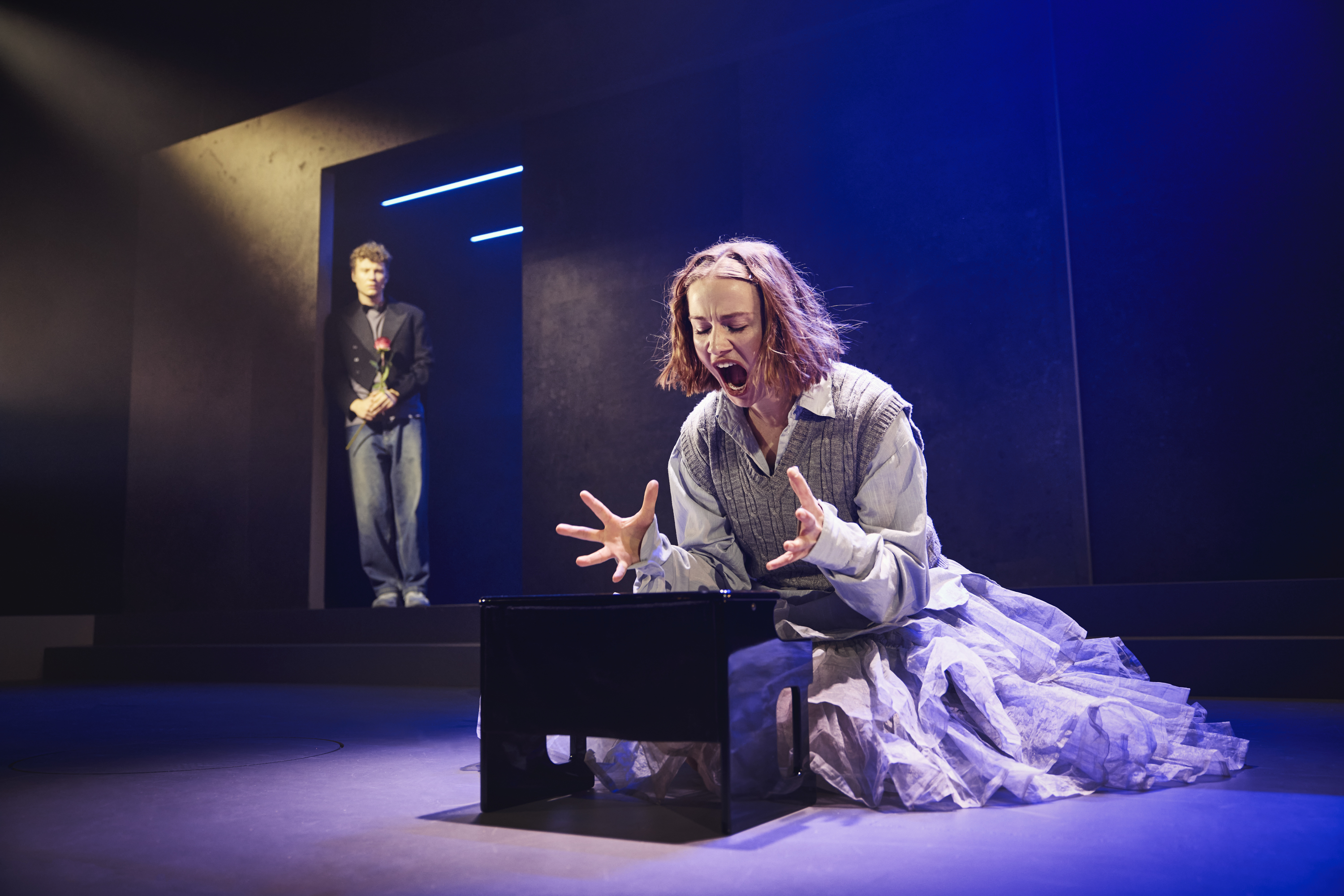 En pige sidder på hug foran en lille klaver på scenen i musicalen Next to Normal på Odense Teater