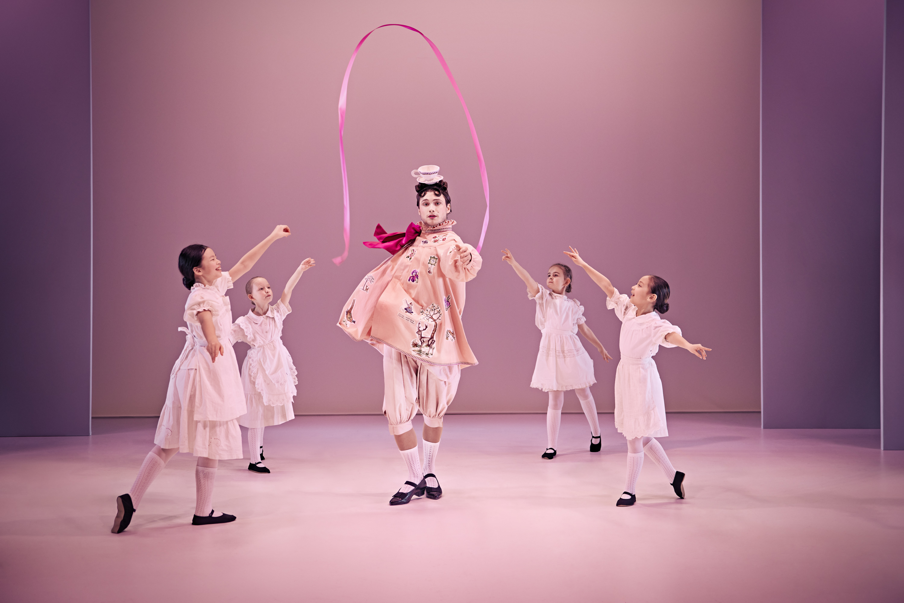 Den snobbede bror fra Klodshans med vimpel og dansende balletbørn klædt i hvidt. Fra Teaterforestilling Klodshans på Odense Teater