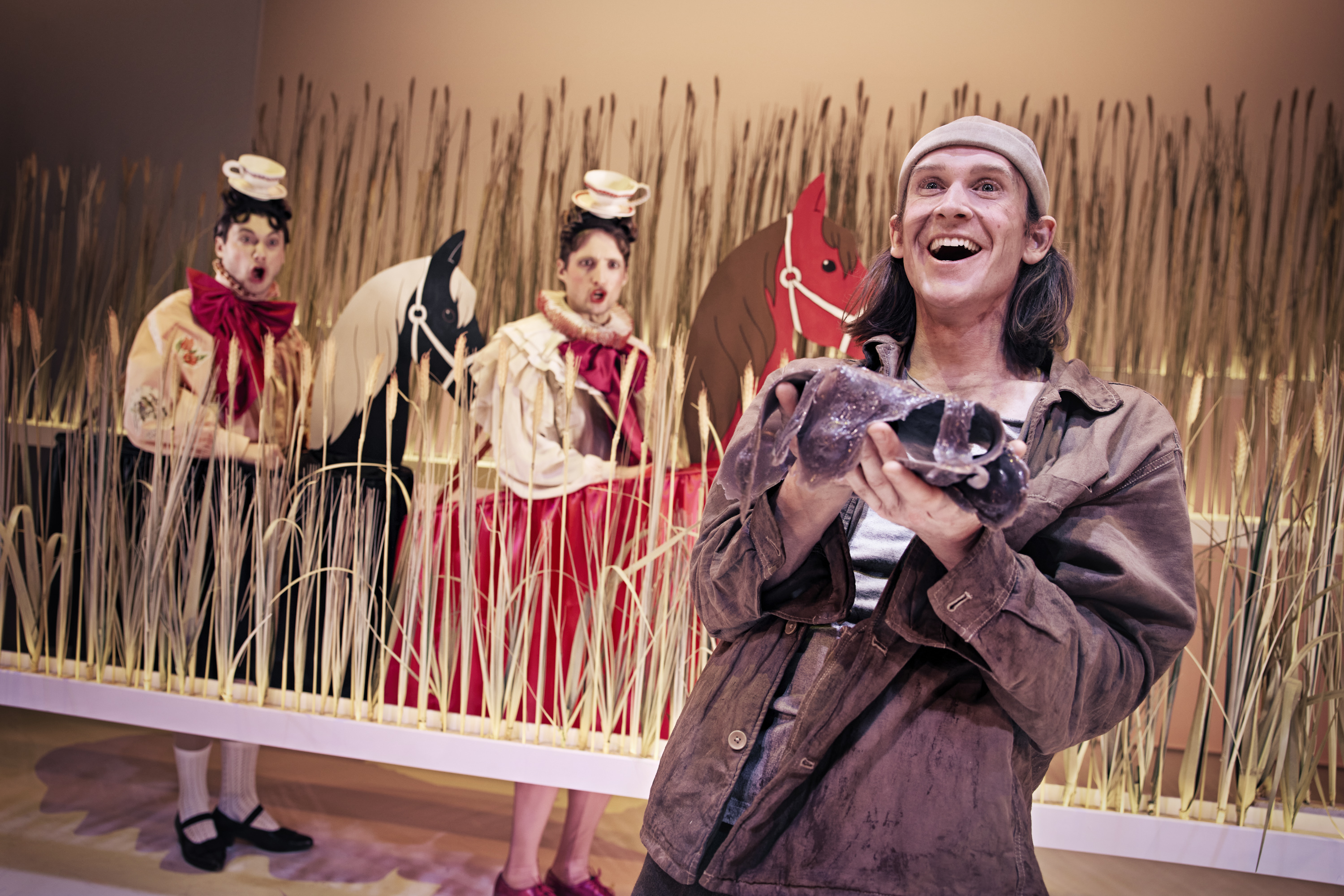 Glad Klodshans og hans to snobbede brødre i baggrunden på papheste i kornmark. Fra Teaterforestilling Klodshans på Odense Teater