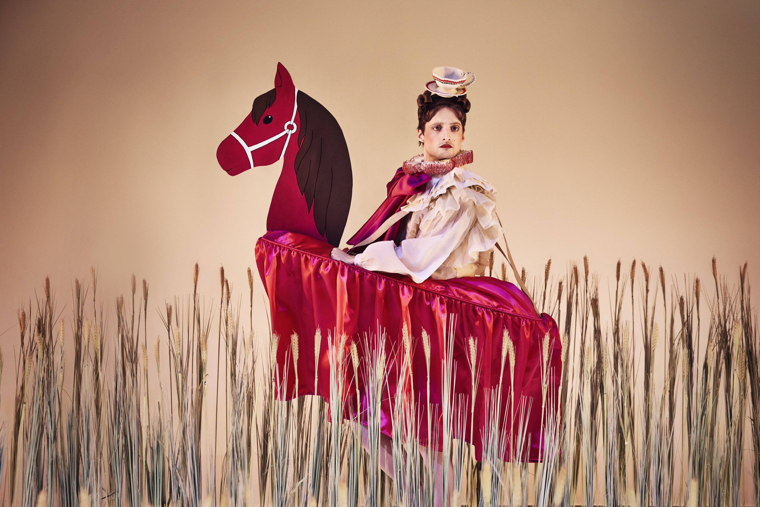 Den snobbede bror fra Klodshans på kunstig hest i en kornmark. Fra Teaterforestilling Klodshans på Odense Teater