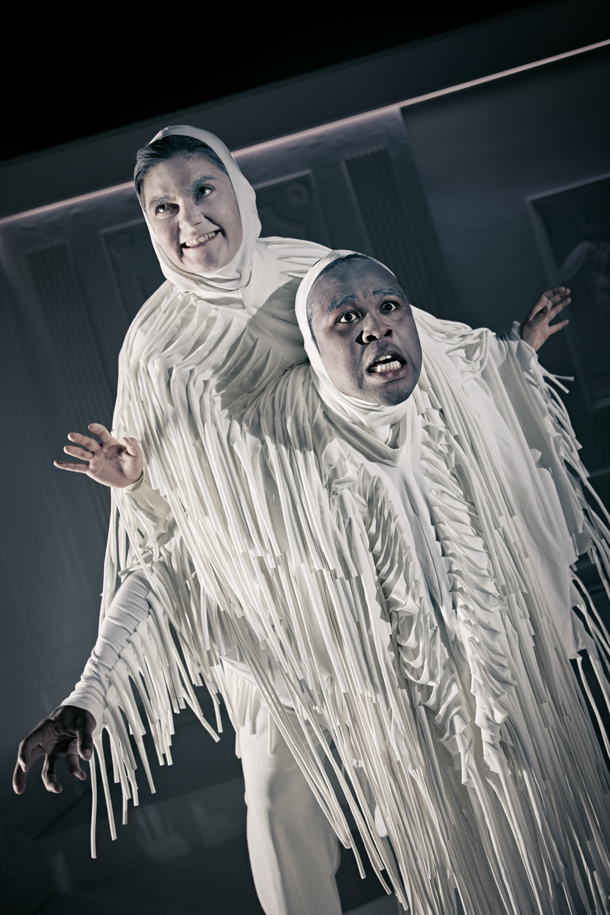 To personer i hvidt kostume hænger sammen. Fra forestilling Resten kender du fra film på Odense Teater